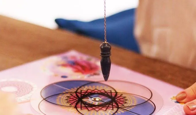 Pêndulo sobre uma mesa radiônica durante uma sessão.